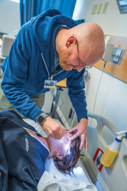 KCC nursing instructor Richard Webb checks the pupils on “Lucina” the newly acquired labor and delivery simulator at the college.